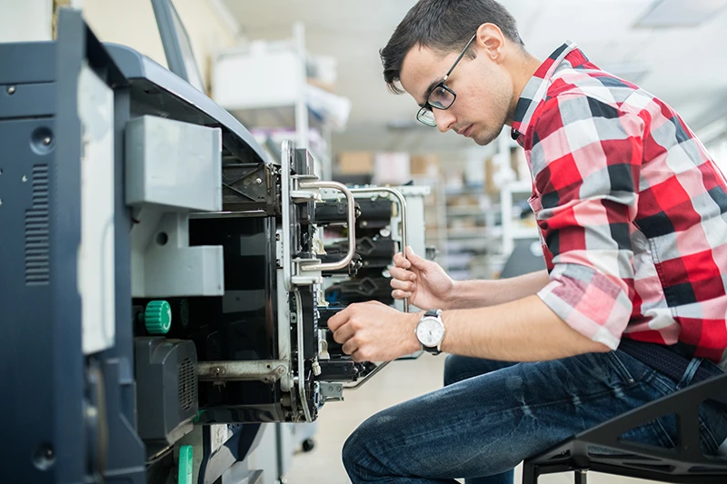 Servisní technik pracující na průmyslové tiskárně